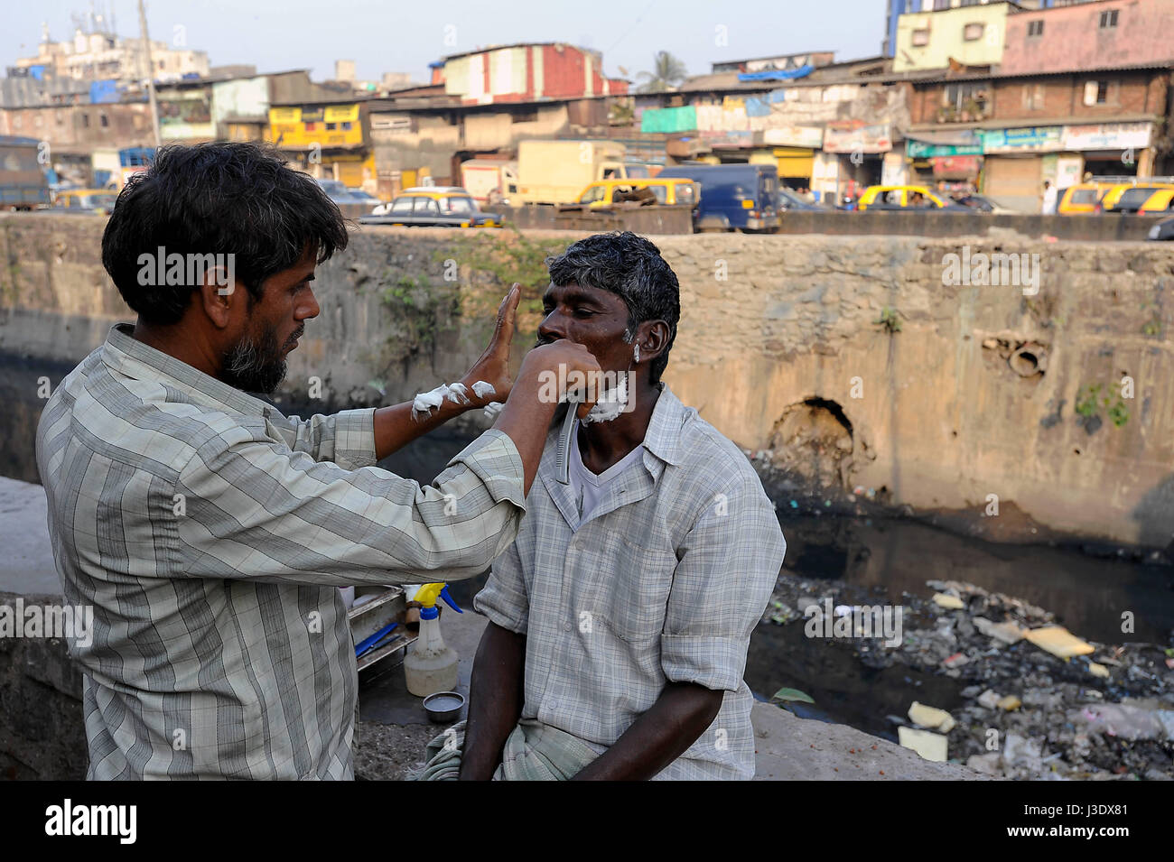 Mumbai, Maharashtra, Indien, Asien, eine Straße Barbier in den Dharavi Slum Stockfoto