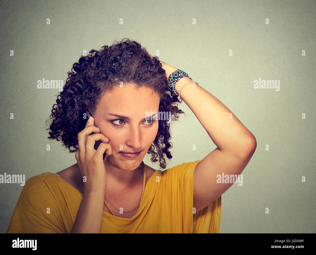 Das Porträt ist unglücklich, dass die junge Frau am Handy schaut gestresst auf graue Wand Hintergrund isoliert. Menschlichen Gesichtsausdruck, Emotionen, schlechte Nachrichten Stockfoto