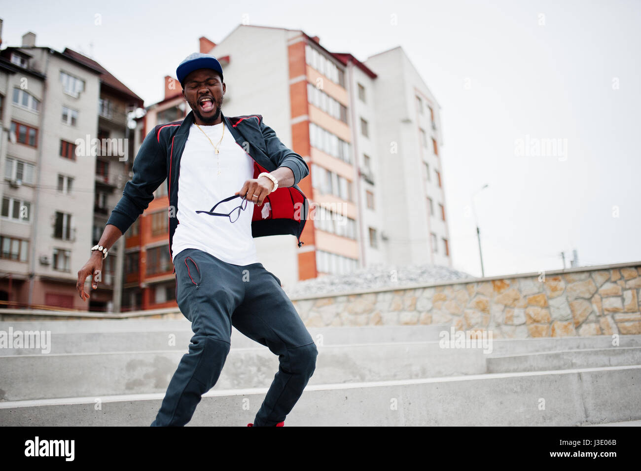 Porträt von stilvollen afrikanischen amerikanischen Mann auf Sportbekleidung, Mütze und Brille springen. Schwarze Männer Emotion Modell Streetfashion. Stockfoto