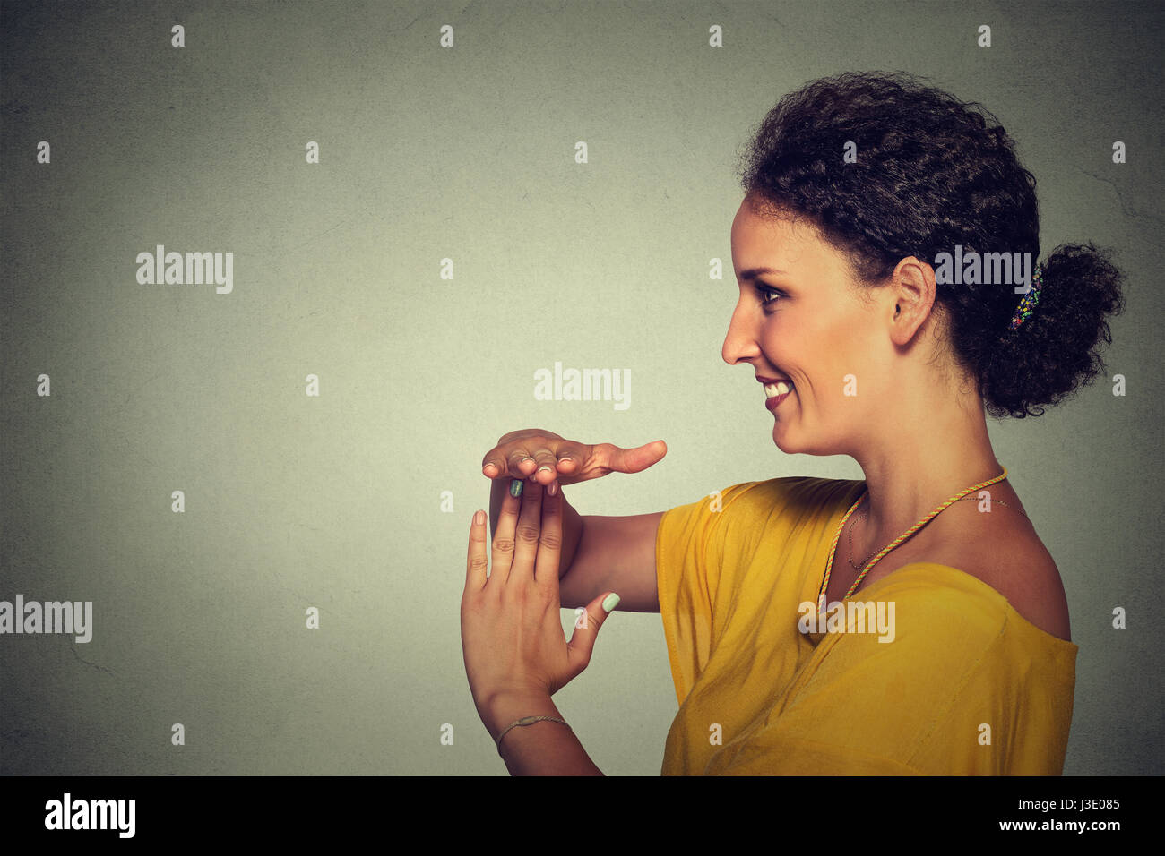 Seite Profilbildnis isoliert jung, glücklich, lächelnde Frau, die Auszeit Geste mit Händen graue Wand Background. Positive menschliche Emotion Gesichts ex Stockfoto