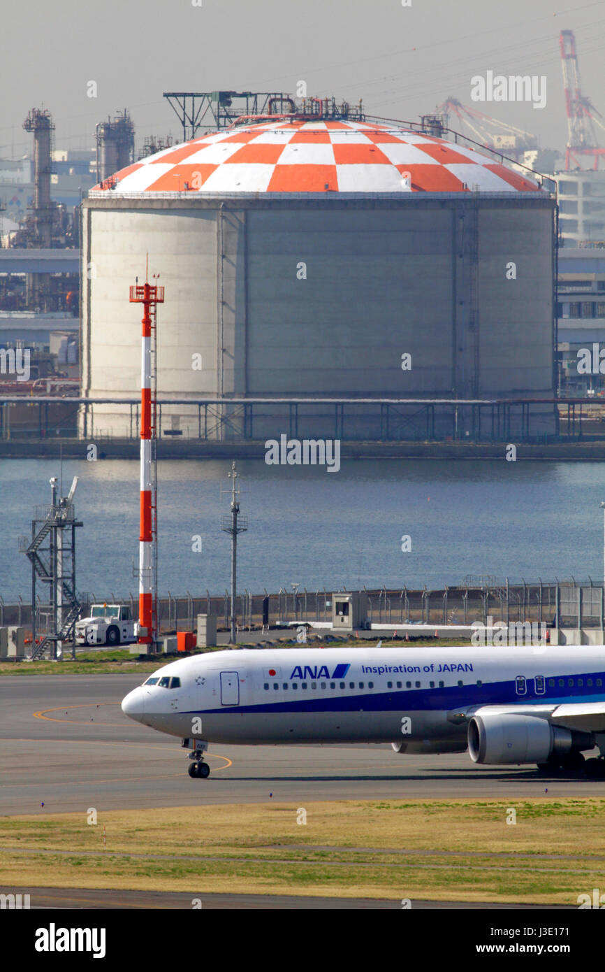 ANA Boeing 767 Besteuerung am Flughafen Haneda in Tokio. Kawasaki Industriegebiet im Hintergrund. Stockfoto