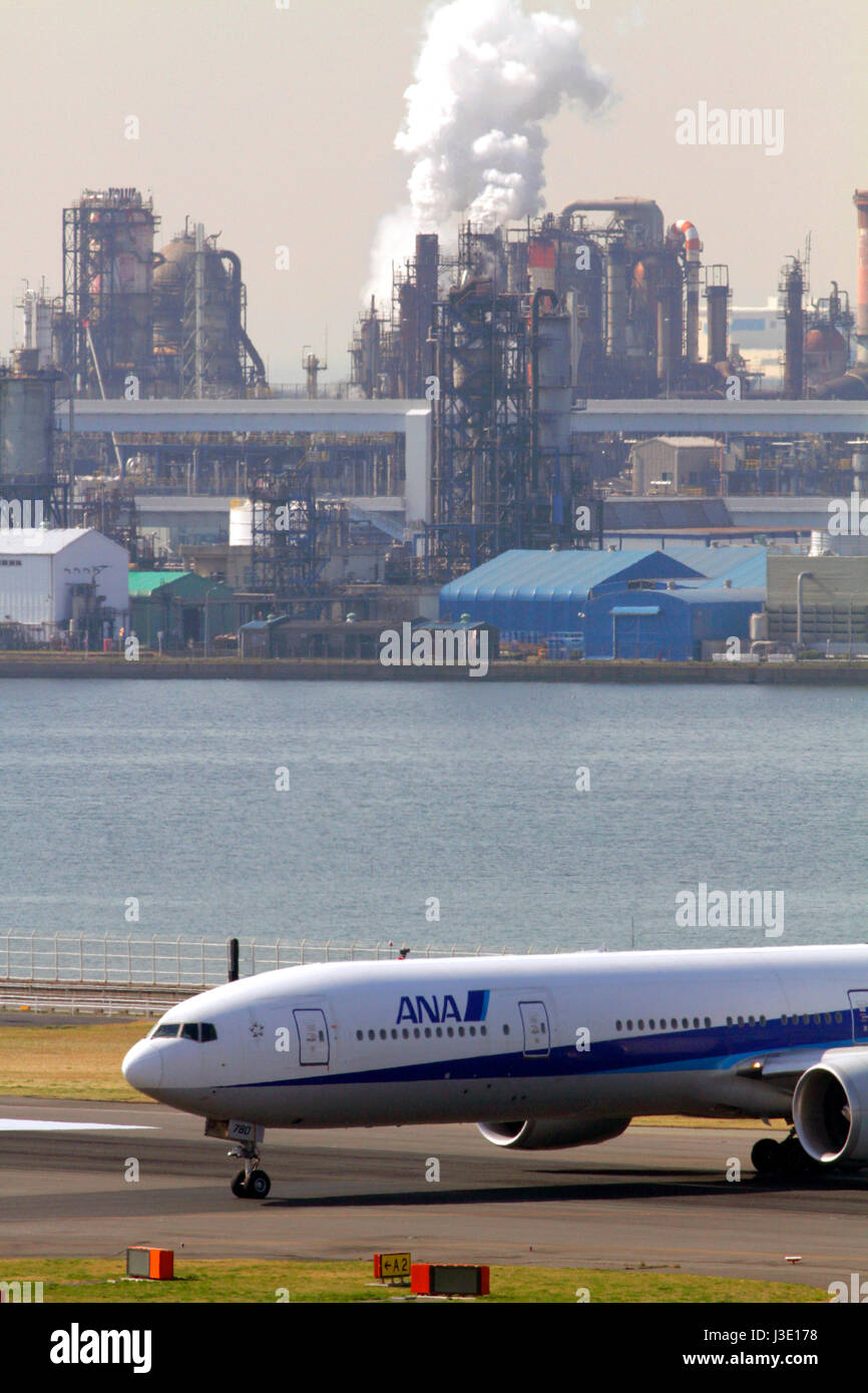 ANA Boeing777 Besteuerung am Flughafen Haneda in Tokio. Kawasaki Industriegebiet im Hintergrund. Stockfoto