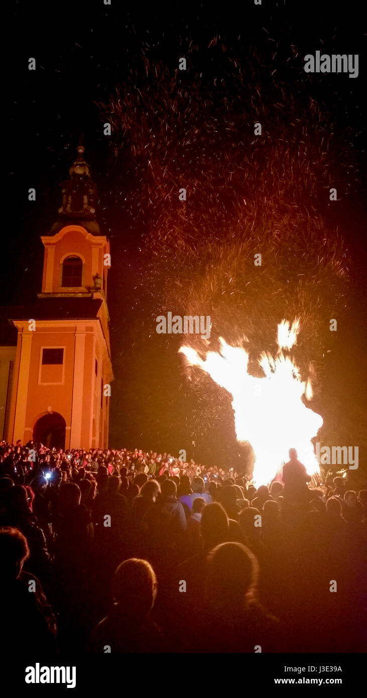 Lebendige traditionelle Lagerfeuer mit zahlreichen Gruppe von Personen in der Nähe von Kirche Stockfoto
