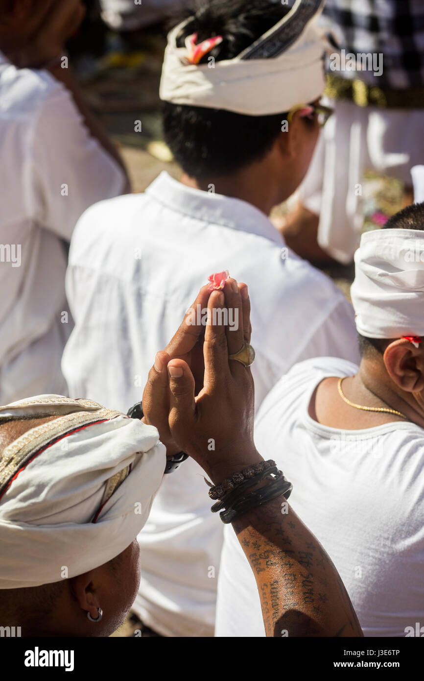 Balinesische Männer mit Händen zusammen im Gebet während einer religiösen Zeremonie gekleidet im balinesischen zeremonielle Kleidung, halten ihre Hände über dem Kopf Stockfoto