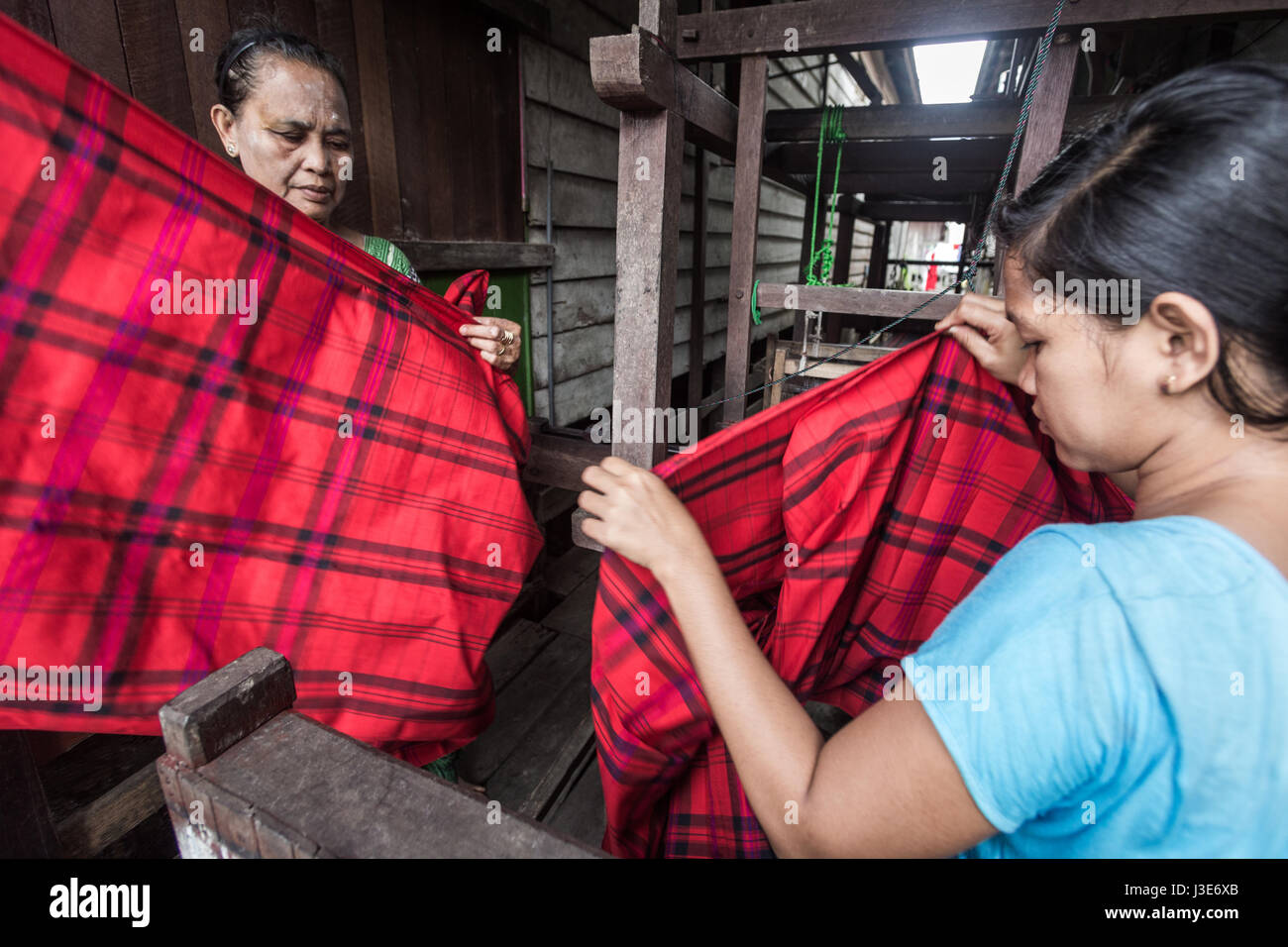 Traditionelle Weber arbeitet an Samarinda Sarongs in Kalimantan. Die orientalischen Weber verwenden traditionelle Methoden, um authentische Kapok Sarongs zu machen Stockfoto