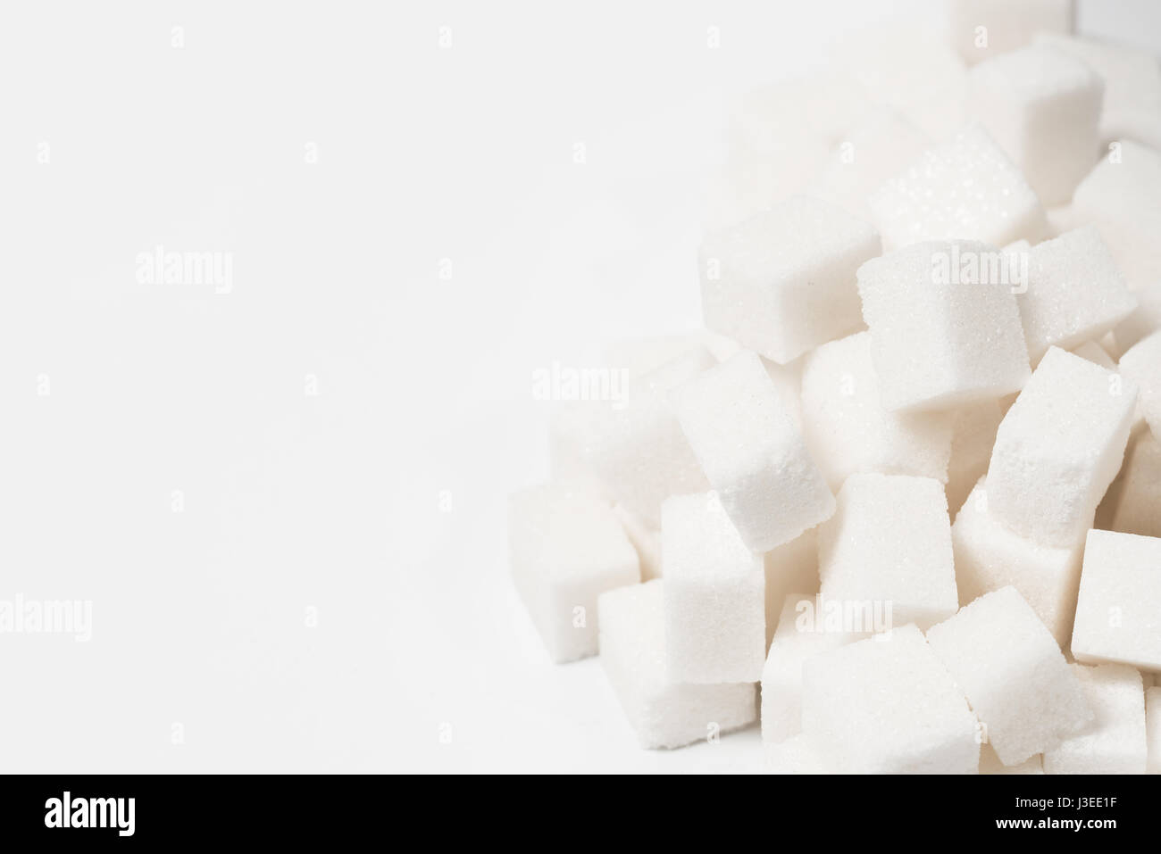 Zucker süße Lebensmittelzutat Hintergrund mit einer engen von einem Haufen von köstlichen weißen Klumpen von Cubes als Symbol für Kochen und Backen und die Diät gesundheitlichen Risiken im Zusammenhang mit Diabetes und Kalorienzufuhr. Stockfoto