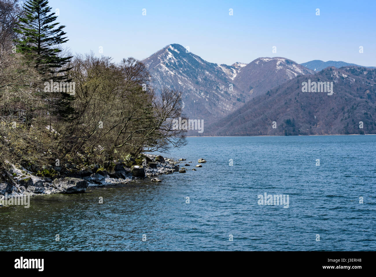 Der See Chuzenji, mit Schnee in den Bergen im Frühjahr mit einer Kappe bedeckt. Stockfoto