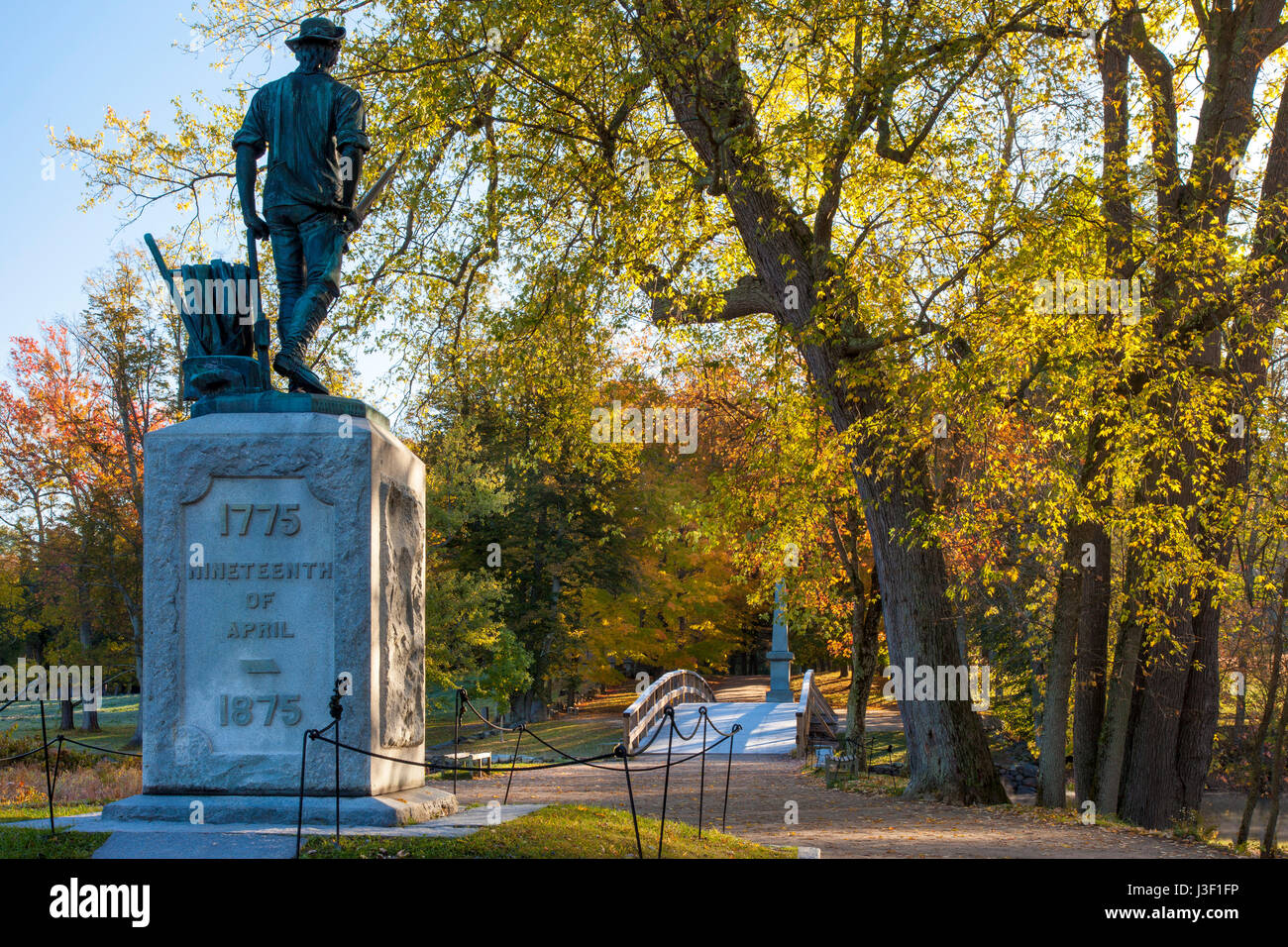 Herbst Farbe in den Ahornbäumen im Morgengrauen über die Minuteman-Denkmal und die Old North Bridge in Concord, Massachusetts, USA Stockfoto