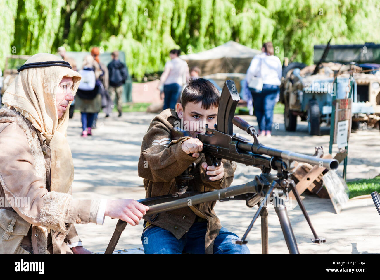Gruß an die 40er Re-enactment Veranstaltung. Kind, Junge, 9-10 Jahre alt, gezeigt wird, wie man Feuer Bren gun von Wüste Ratte re-Enactor. Stockfoto