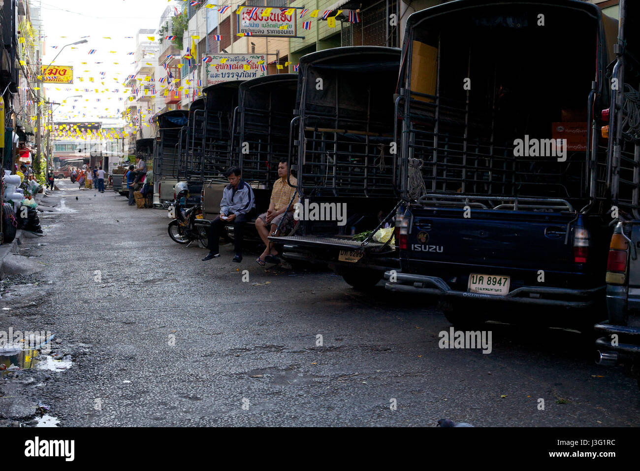 Tuk-Tuk-Fahrer töten Zeit draußen ein Blumenmarkt in Bangkok Stockfoto