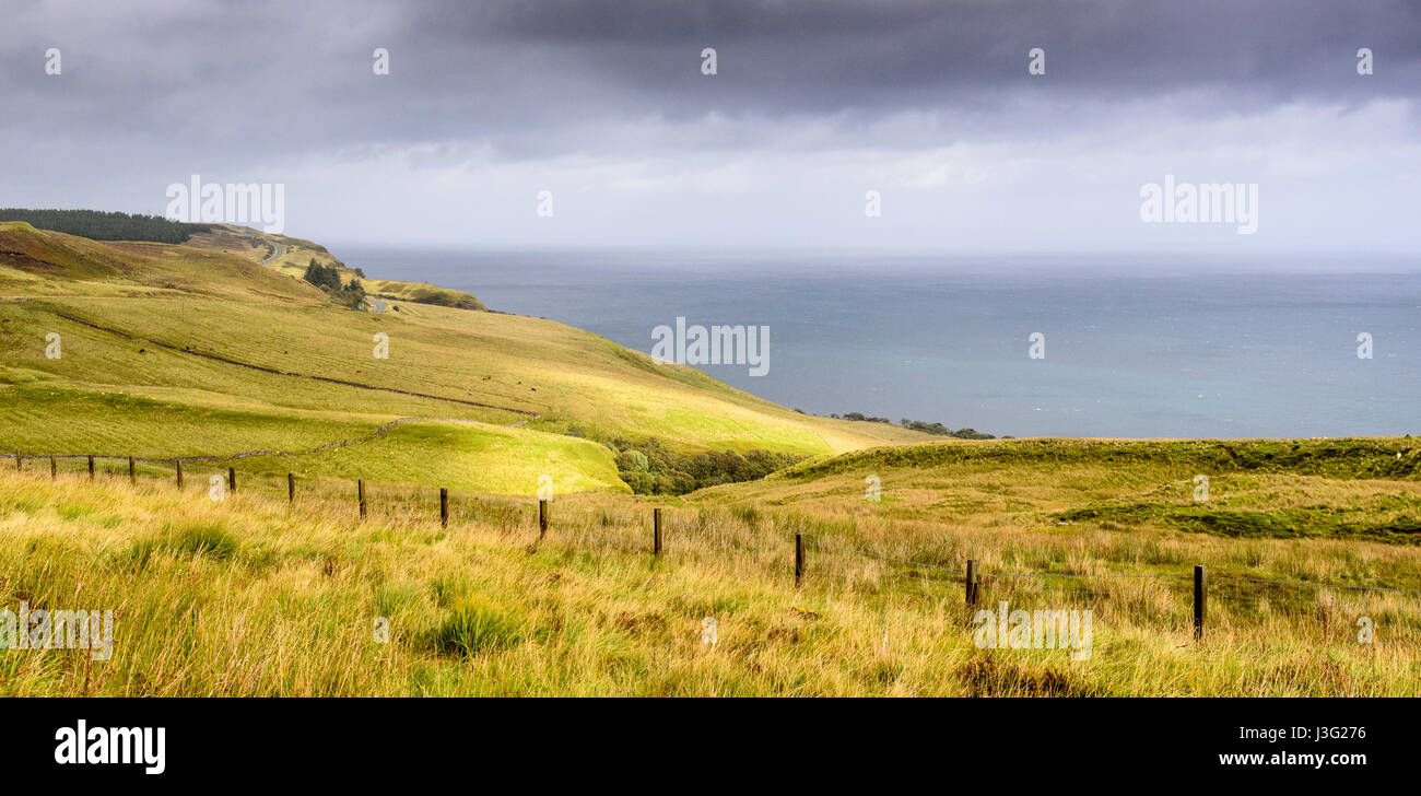 Grüne Weide bedeckt Ausläufern und Klippen mit Blick aufs Meer auf der Halbinsel Trotternish auf der schottischen Insel Skye. Stockfoto