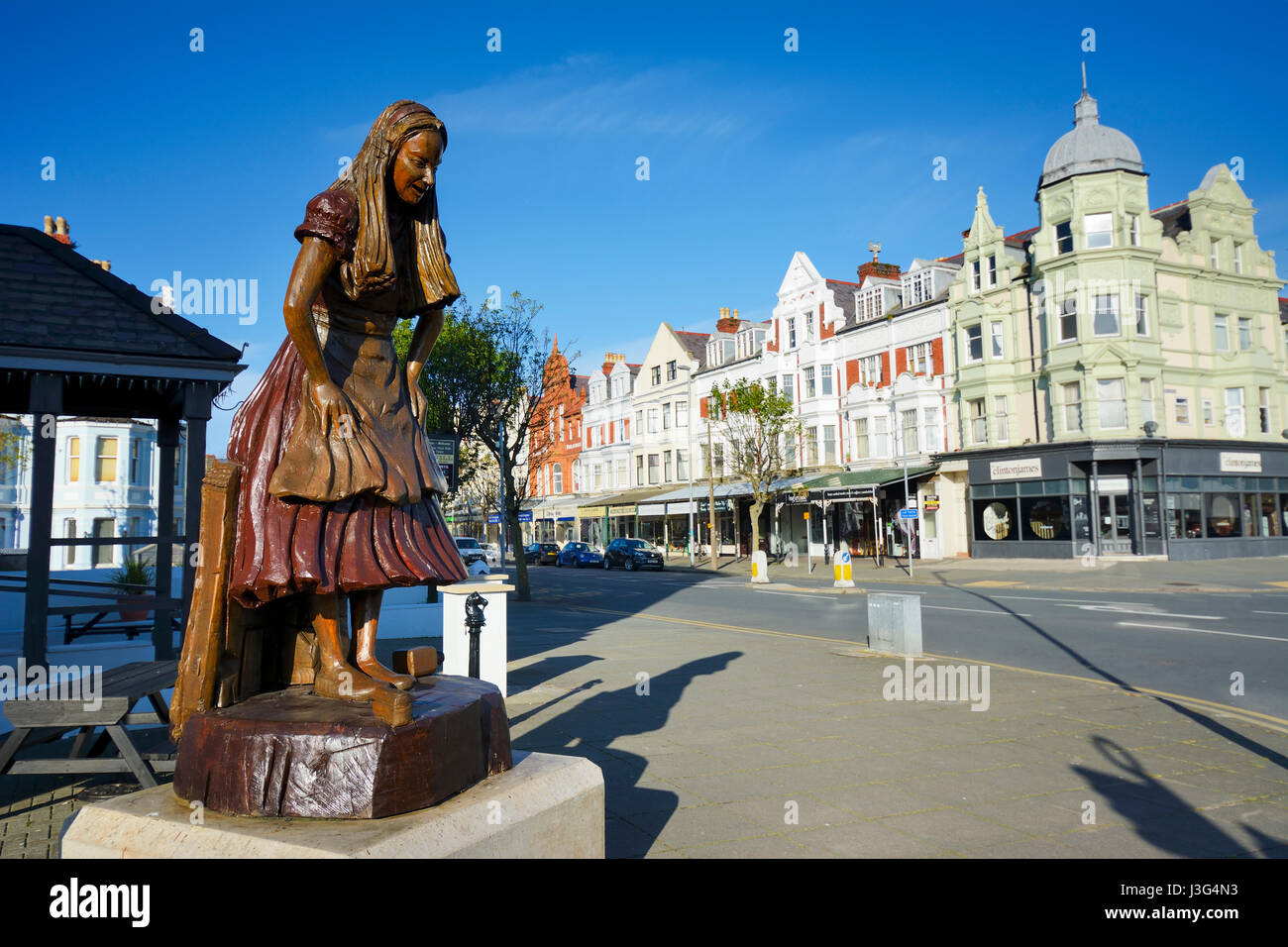 Alice im Wunderland geschnitzte Holzfigur in Llandudno Hervorhebung die Verbindung der Stadt mit Alice Pleasance Liddell, Alice im Wonderlan Stockfoto