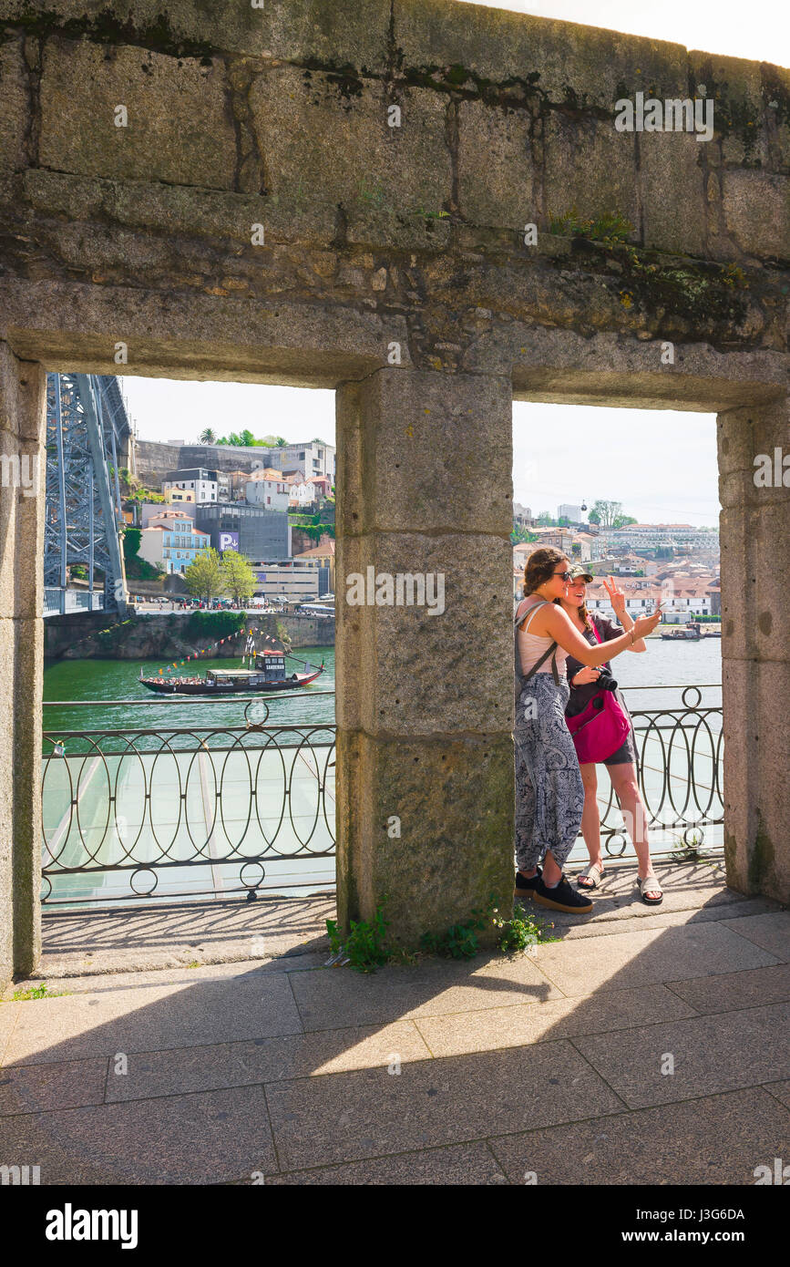 Mädchen Urlaub, zwei junge Frauen Touristen inszenieren ein Selfie-Foto mit dem Fluss Douro als Hintergrund, Ribeira Waterfront, Porto, Portugal Stockfoto