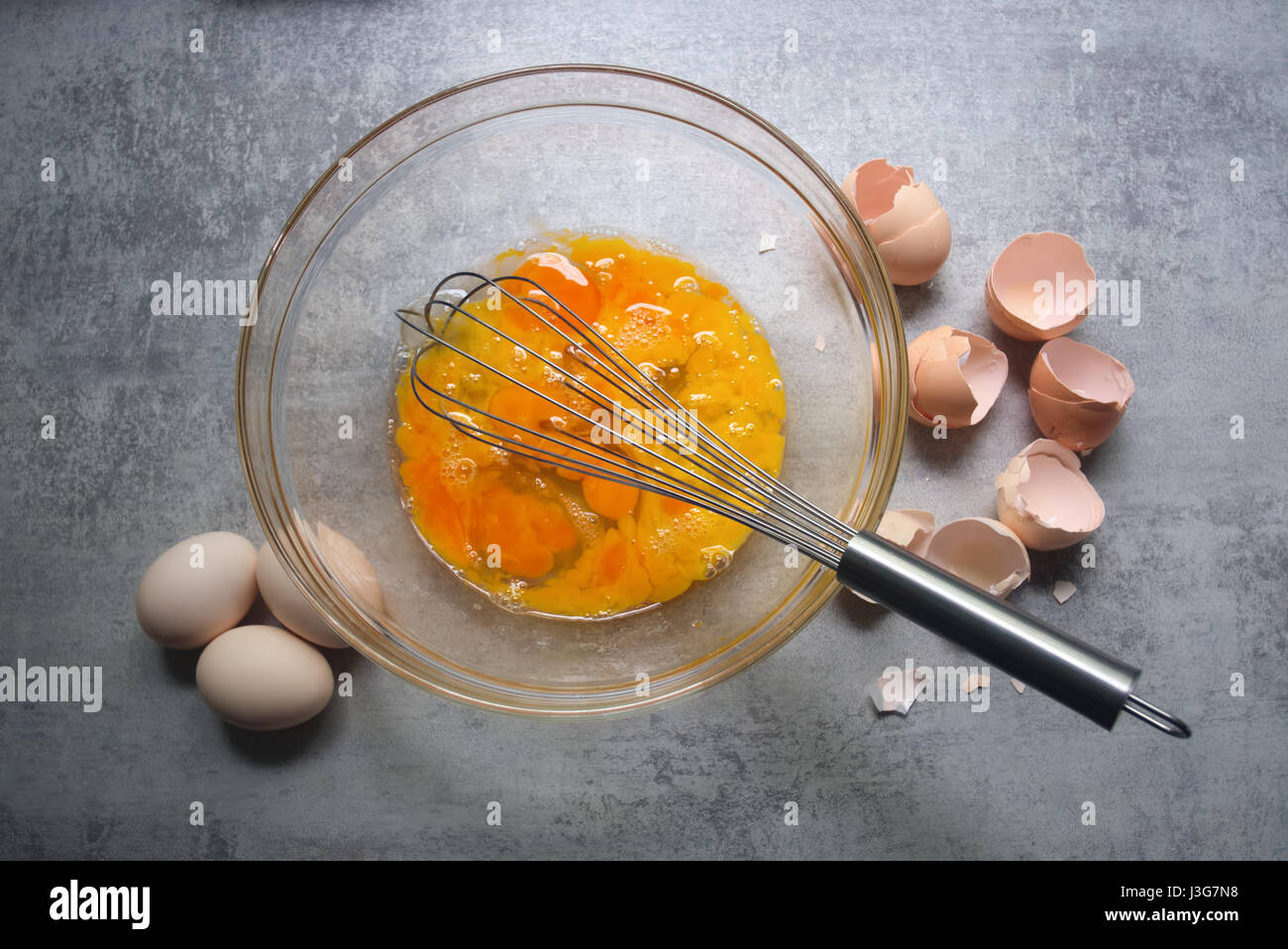 Rohen Eiern in Glasschüssel am Küchentisch. Vorbereitung der Omelette Stockfoto