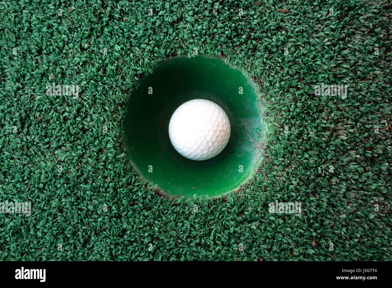 Mini-Golf-Szene mit Ball und Loch. Einsetzbar wie der Hintergrund. Sonniger Tag am Kurpark Stockfoto