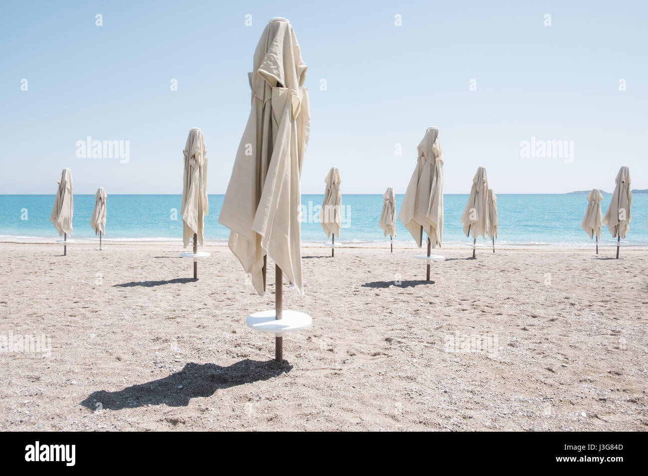 Reihe von Sonnenschirm Sonnenschirme am Strand. Ruhigen Blick auf das Mittelmeer. Sonniger Tag mit strahlend blauen Himmel. Minimalistische Szene. Ort: Turke Stockfoto