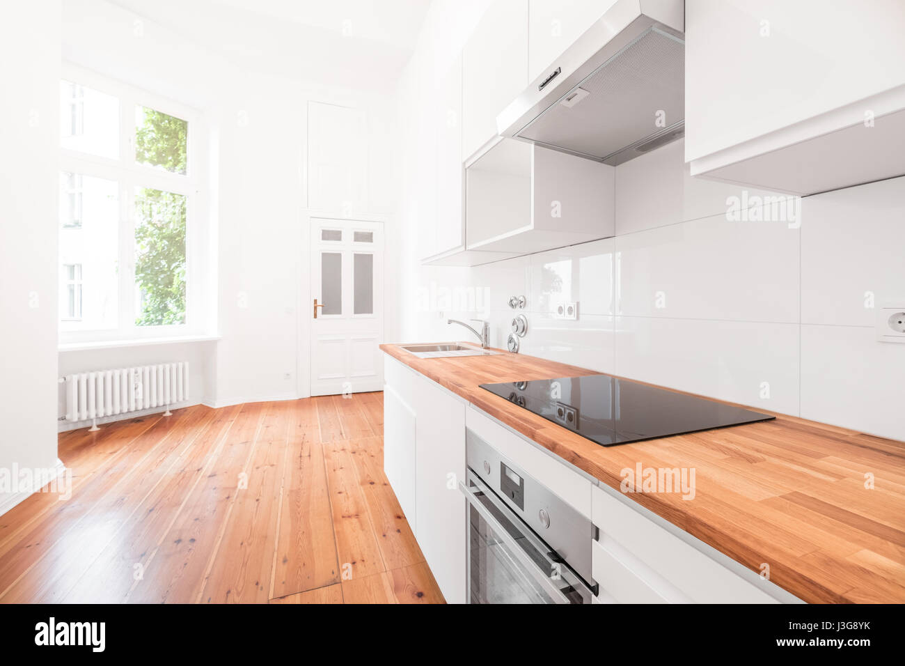 weiße Küche - moderne neue Küche mit Holzboden Stockfoto