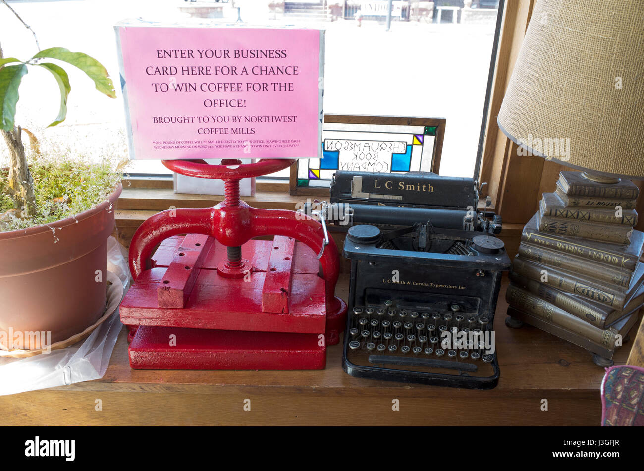 Antike Schreibmaschine, Buch Presse, Pflanze und Lampe auf dem Display in der Buchhandlung Chequamegon Buch & Coffee Company.  Washburn Wisconsin WI USA Stockfoto