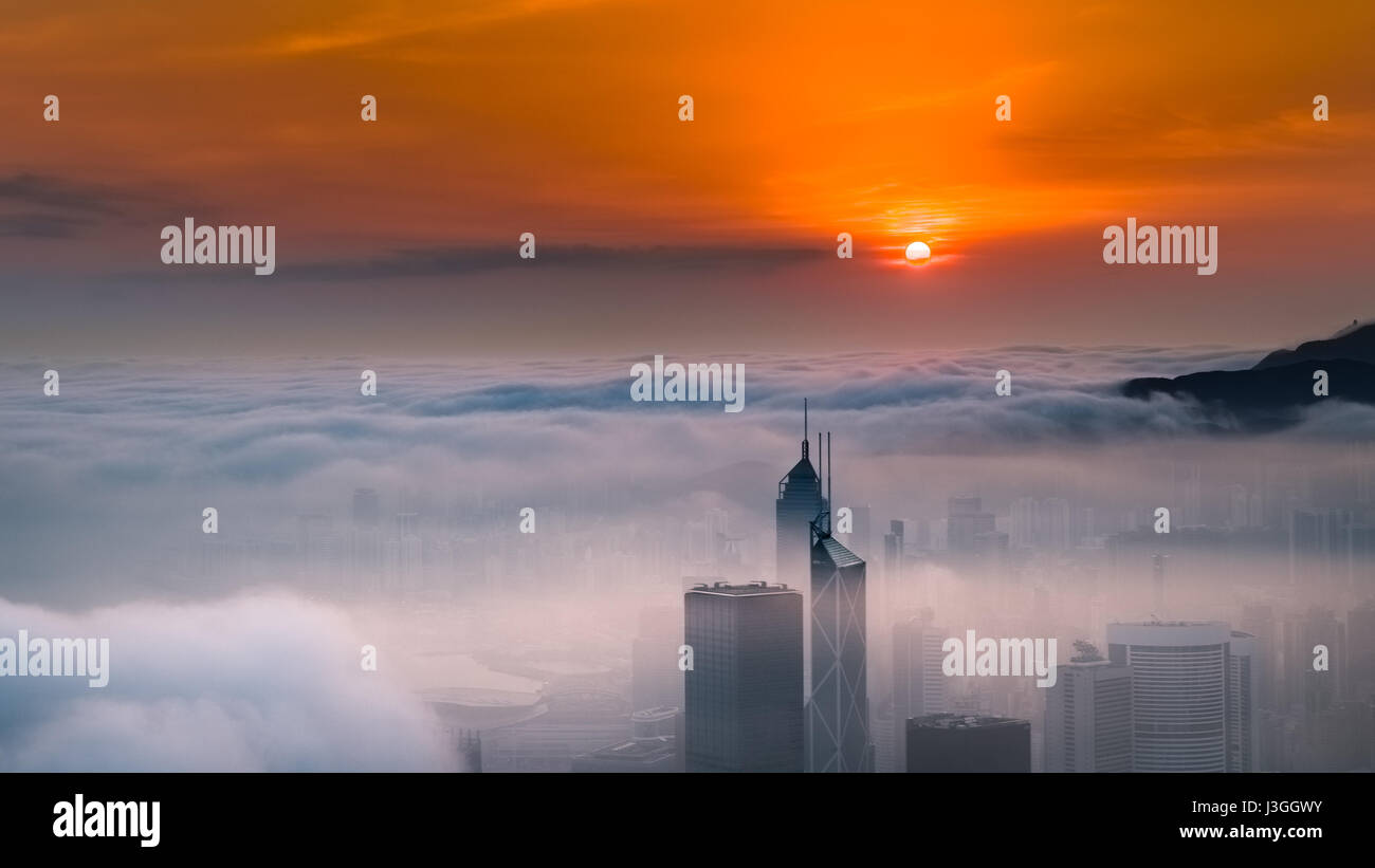 Misty-Stadt und den Hafen bei Sonnenaufgang - Victoria-Hafen von Hong Kong Stockfoto