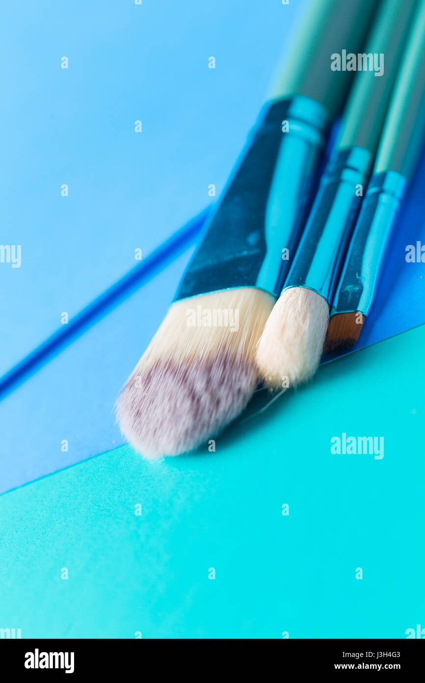 Ihr Leben in Shades of Blue: Stillleben mit einem Make-up-Pinsel platziert auf einem Multi-Ton-Schattierungen von blau. Stockfoto