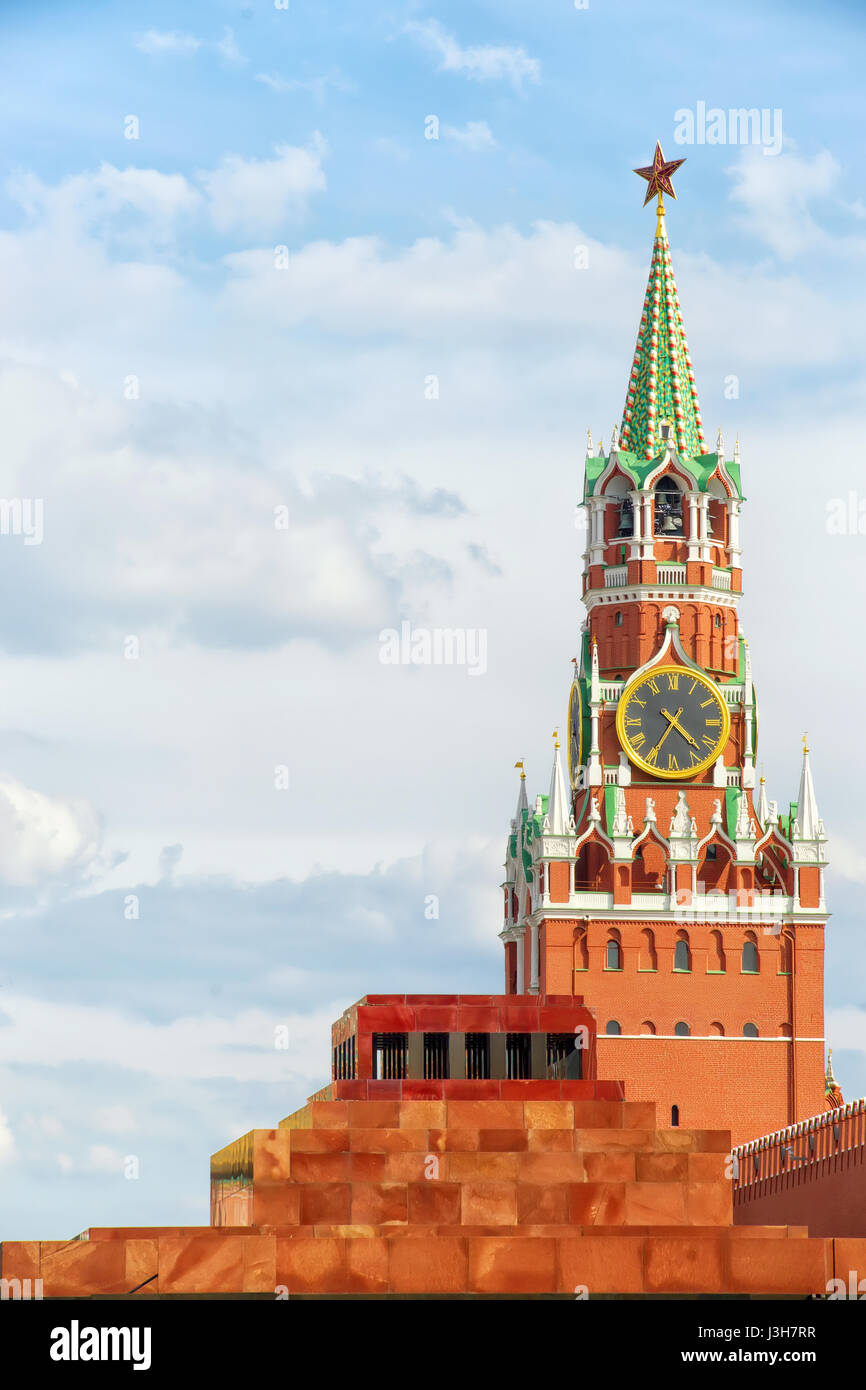 Roter Platz, Moskau, Russland. Spasskaya Tower des Kreml mit Stern und Uhr und Lenin Mausoleum. Vertikale Zusammensetzung, Textfreiraum am bewölkten Himmel. Stockfoto