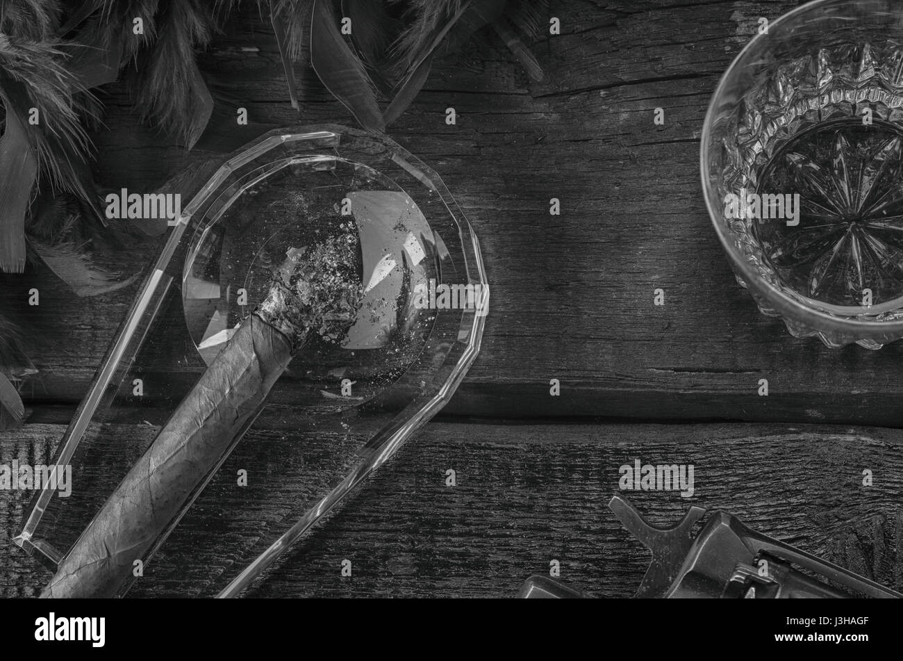 Revolver, Zigarren Aschenbecher, Whiskeyglas und blaue Federboa Stockfoto