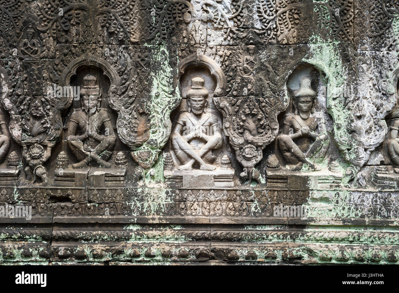 Reihe von antiken Apsara-Tänzerinnen geschnitzt in verwittertem Stein an den Tempelruinen von Angkor Wat in Siem Reap, Kambodscha Stockfoto