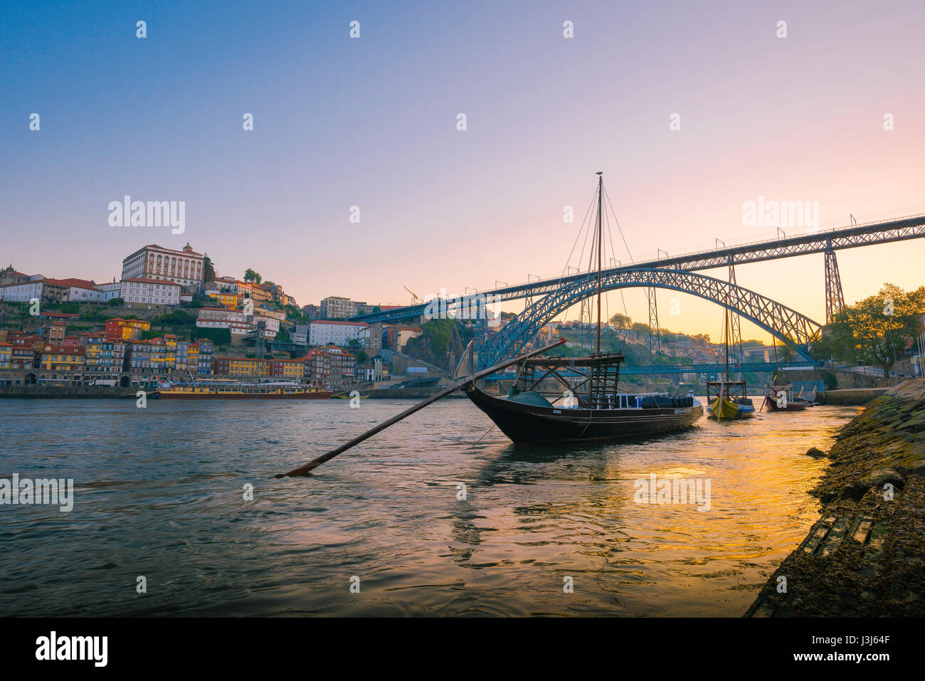 Douro Porto Stadt, Blick auf ein traditionelles Rabelo Boot auf dem Douro Fluss mit der Skyline von Porto bei Sonnenaufgang im Hintergrund, Portugal, Europa. Stockfoto