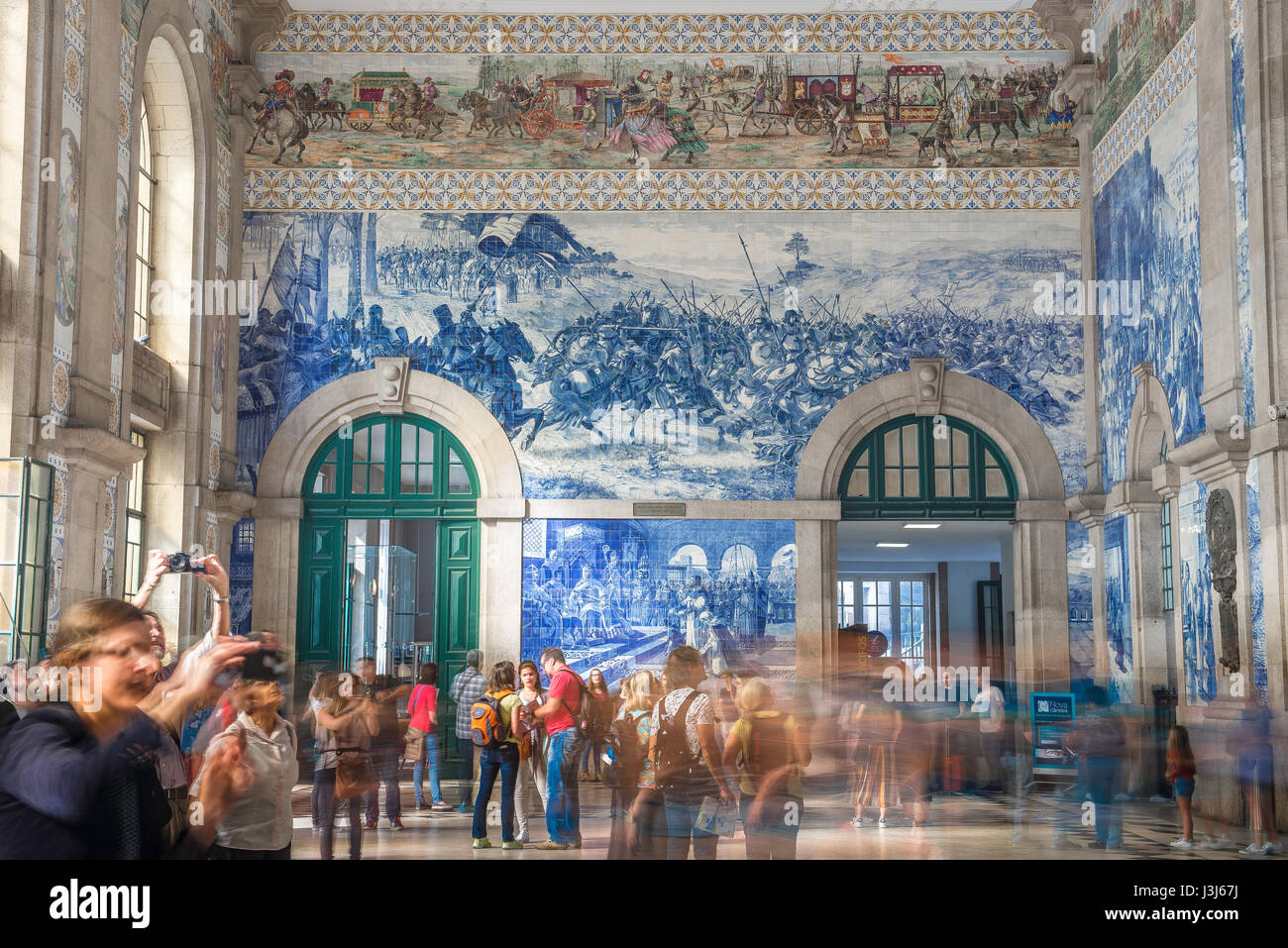 Azulejos von Porto Portugal, Blick auf die geschäftige Eingangshalle des Bahnhofs Sao Bento, geschmückt mit blauen Azulejo-Fliesen, die historische Szenen darstellen. Stockfoto