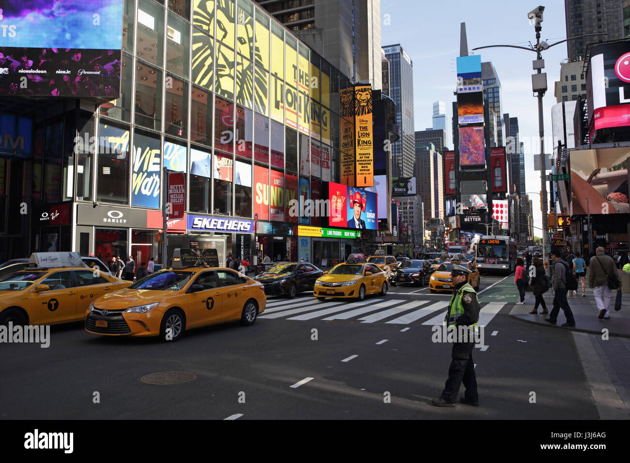 Morgen im Times Square New York City an der Seventh Avenue West 44th Street nach Norden uptown. Ein NYPD-Polizisten Uhren gelben Taxis ein Stockfoto