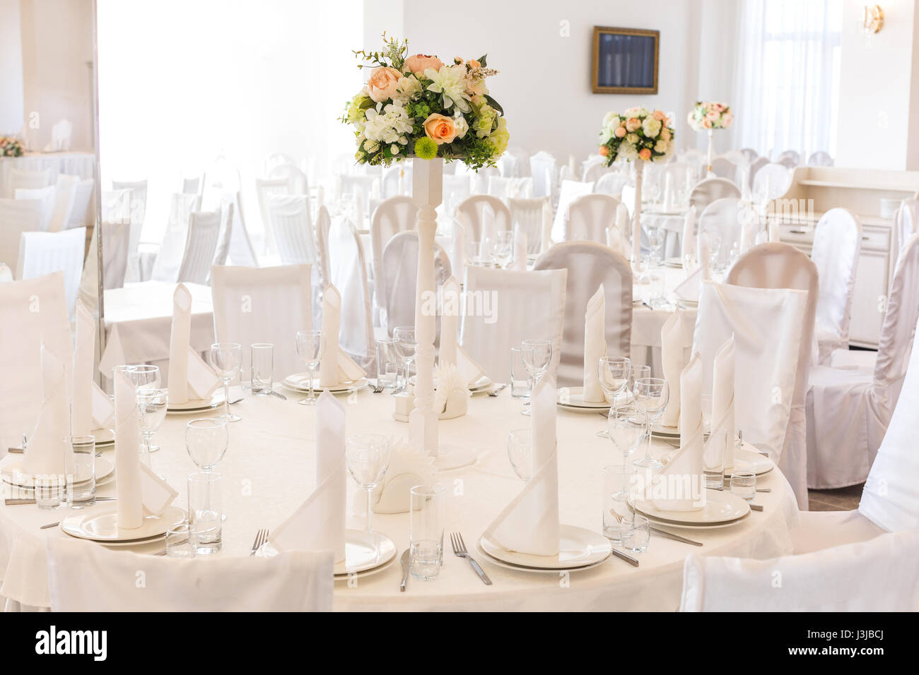Festliche Tischdekoration im klassischen Stil in einem weißen Restaurant Interieur, darlegen. Tisch Dekor Hochzeitskonzept. Bildende Kunst. Erwartung der Gäste. Stockfoto