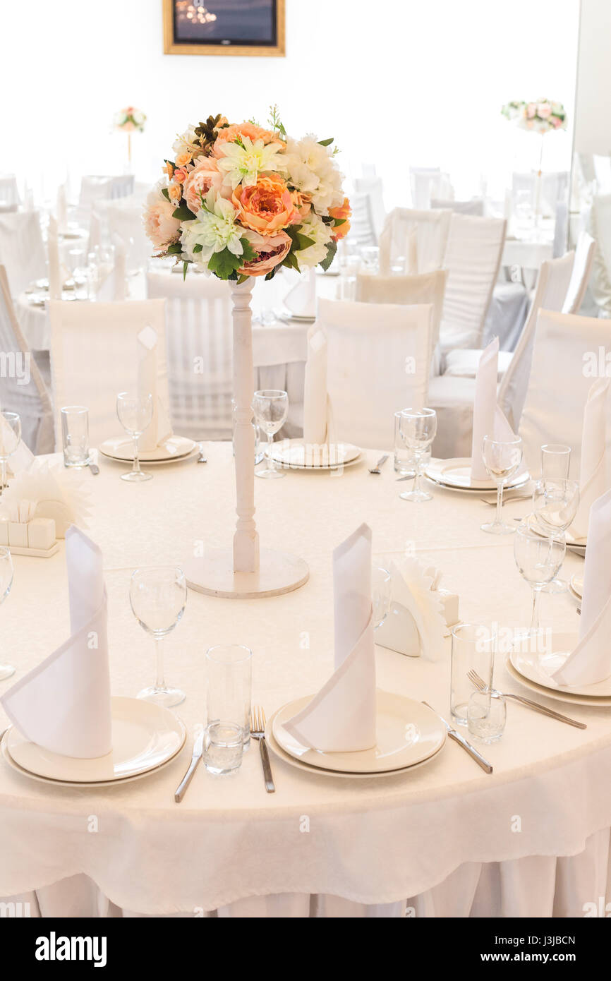 Festliche Tischdekoration im klassischen Stil in einem weißen Restaurant Interieur, darlegen. Tisch Dekor Hochzeitskonzept. Bildende Kunst. Erwartung der Gäste. Verical. Stockfoto