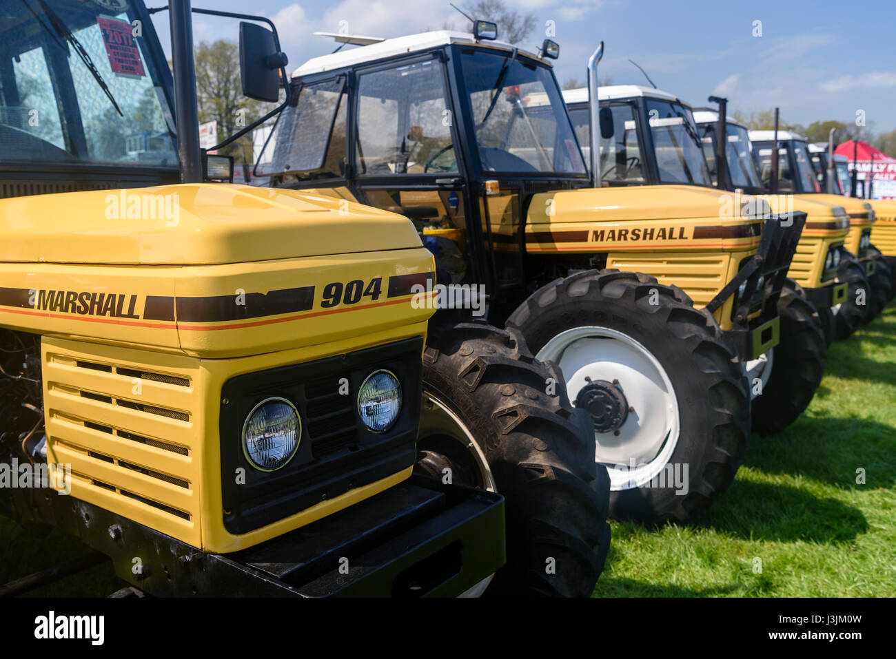 Reihe von gelben Marshall Traktoren bei einer Landwirtschaftsausstellung. Stockfoto