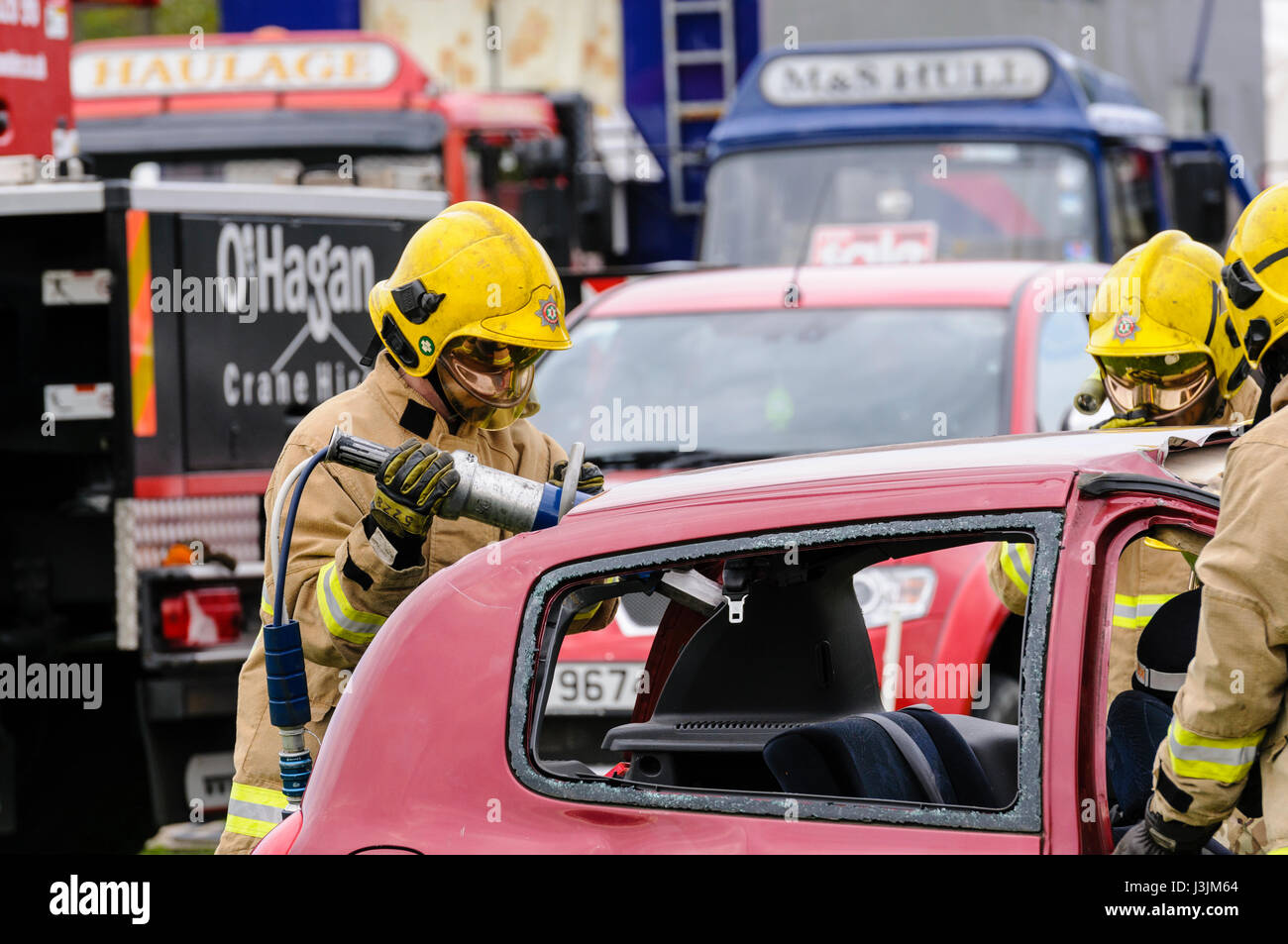 Firecrew aus Nordirland Feuer und Rettung Service zeigen, wie hydraulische Schneidausrüstung verwenden, um eine eingeschlossene Fahrer aus dem Auto nach frei ein Stockfoto
