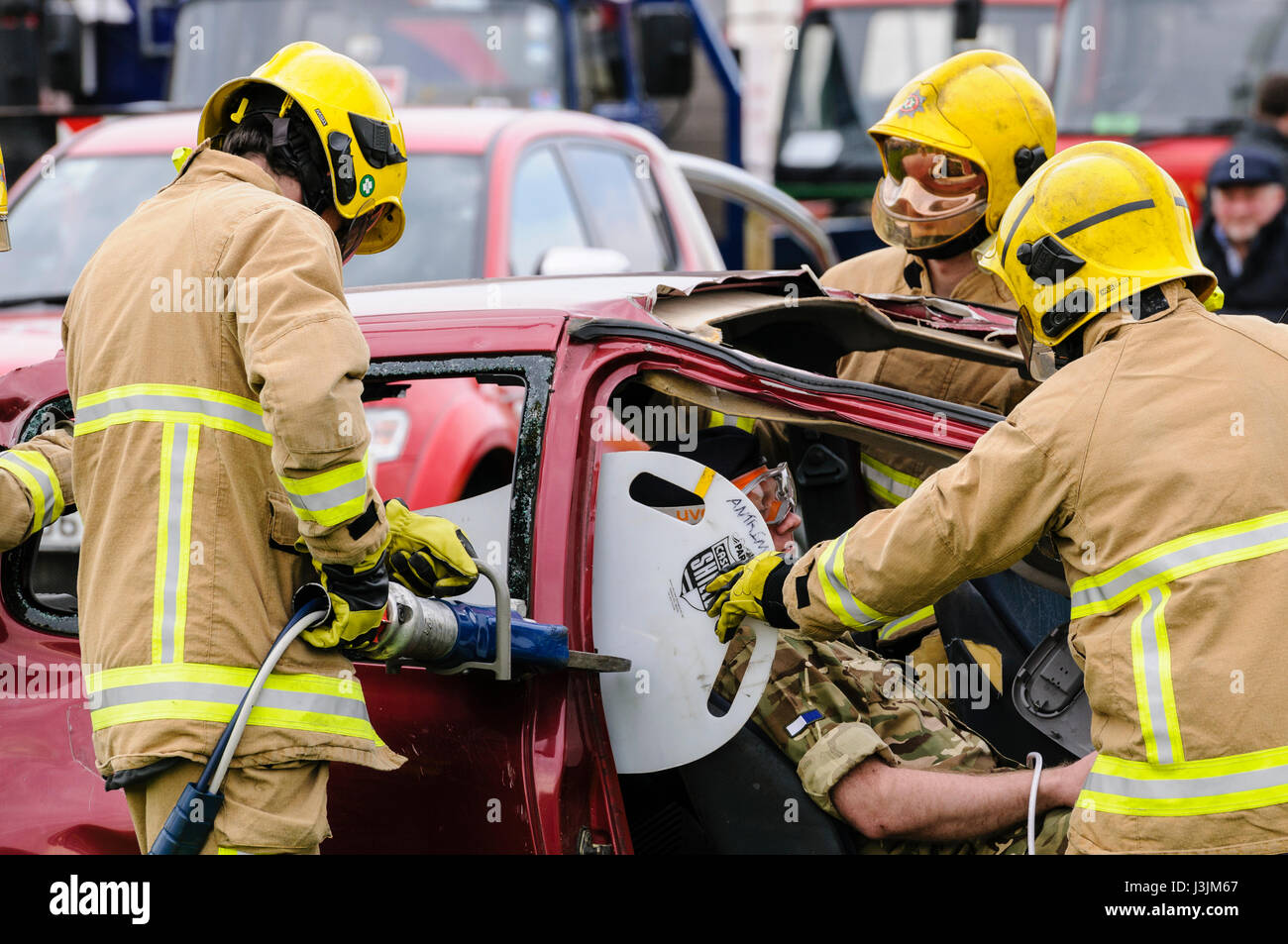 Firecrew aus Nordirland Feuer und Rettung Service zeigen, wie hydraulische Schneidausrüstung verwenden, um eine eingeschlossene Fahrer aus dem Auto nach frei ein Stockfoto