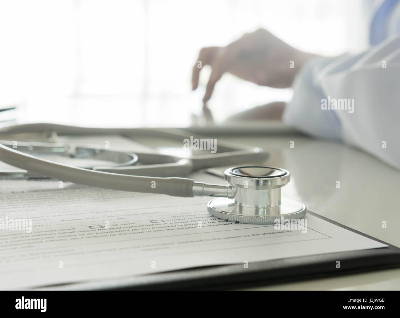 Nahaufnahme von Stethoskop und medizinische Dokumentation im Hintergrund tätiger Arzt Stockfoto