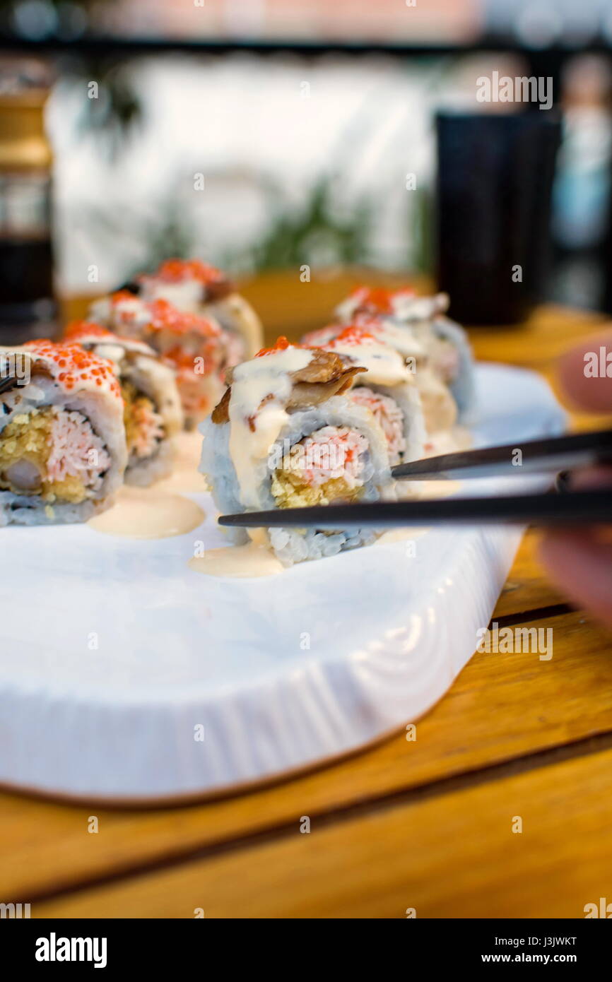 Weibliche Hand nehmend Sushi Rollen mit Stäbchen Stockfoto Weibliche Hand nehmend Sushi Rollen mit Stäbchen Stockfoto