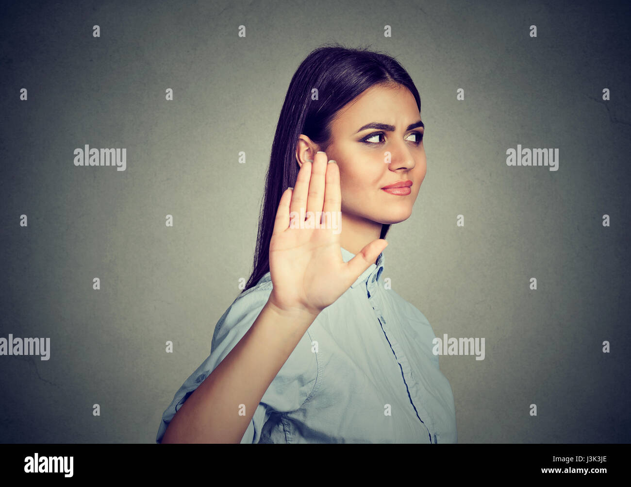 Verärgert böse Frau geben sprechen zur hand Geste mit Handfläche nach außen isoliert auf graue Wand Hintergrund. Negative menschliche Emotionen Körpersprache Stockfoto