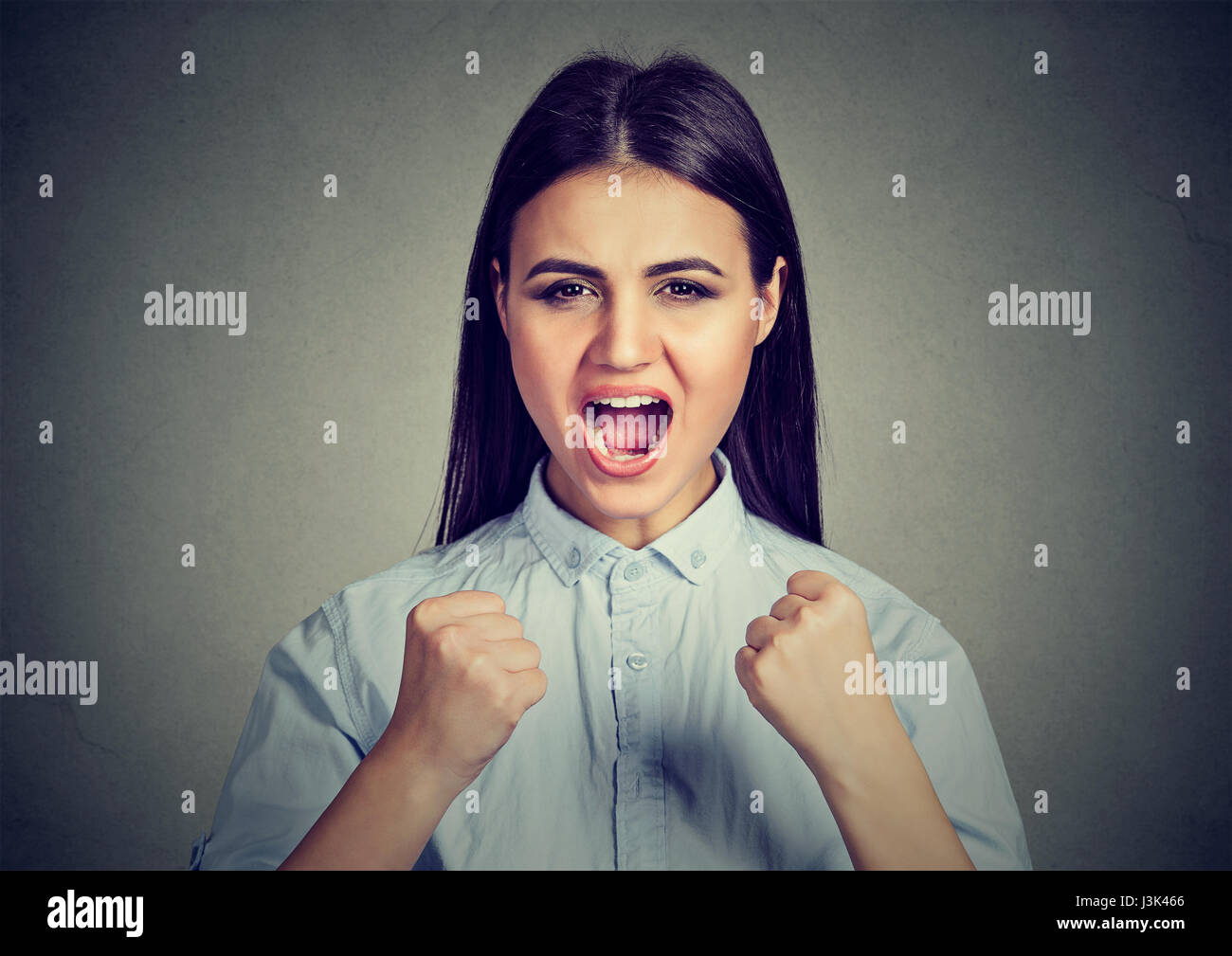 böse Frau schreiend mit Fäusten in Luft Stockfoto
