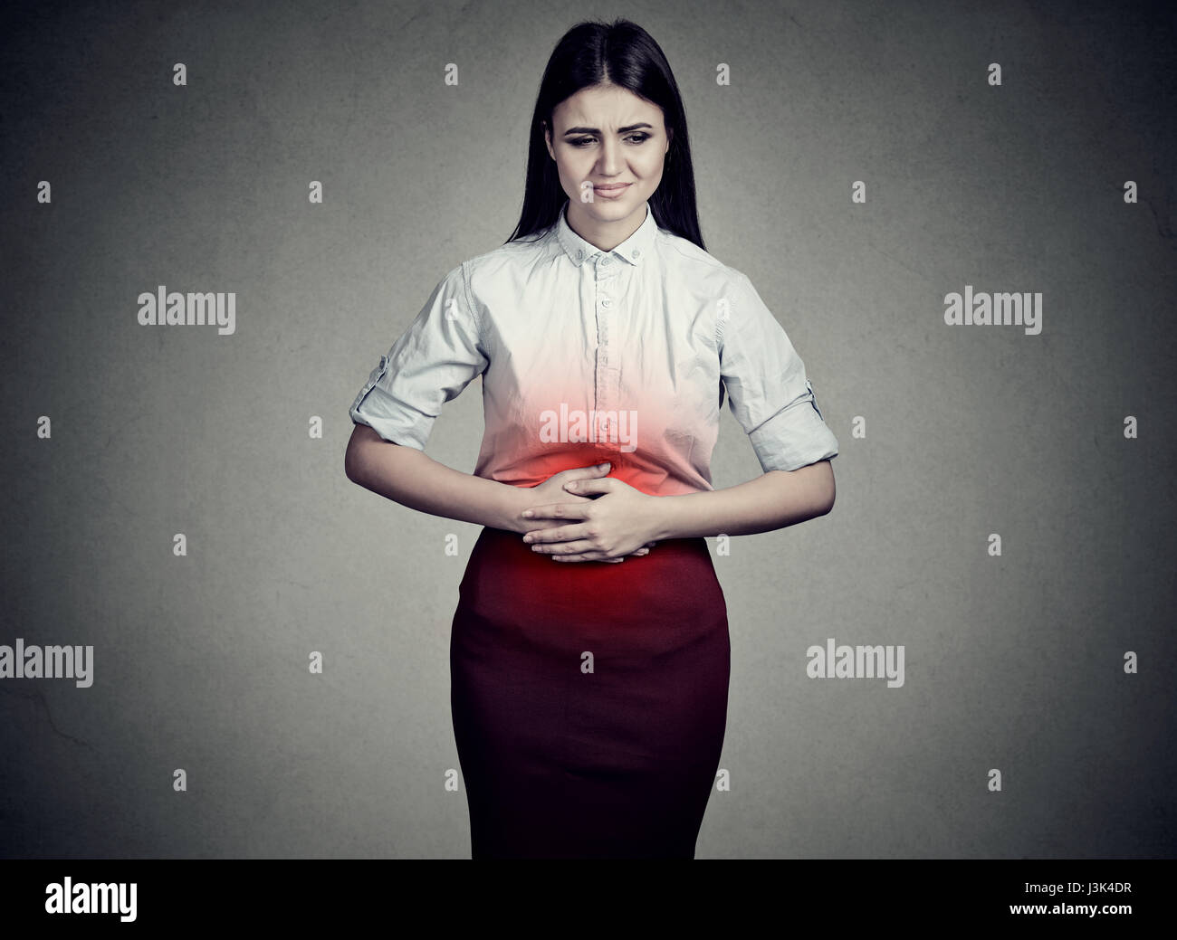 junge Frau mit den Händen auf Magen schlecht Schmerzen Schmerzen Stockfoto