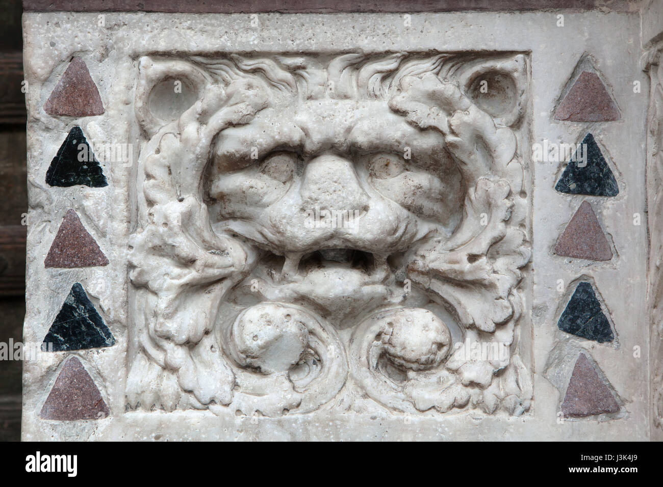 Löwenkopf dargestellt in der romanischen Marmorrelief von Maestro dell'Arca del Battista (ca. 1225) auf das Hauptportal des Genua-Dom (Duomo di Genova) in Genua, Ligurien, Italien. Stockfoto