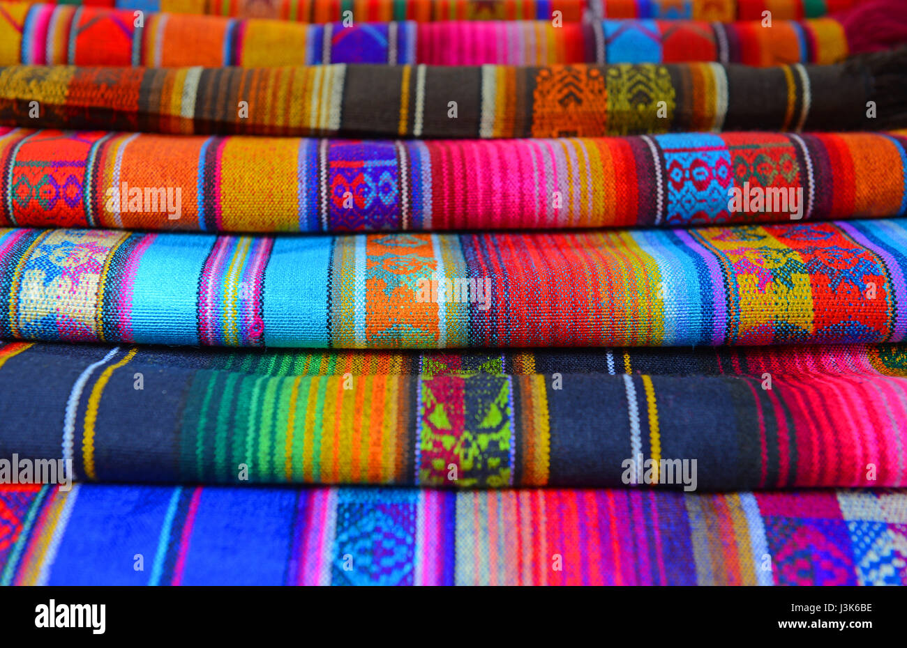 Ein Haufen von traditionellen Anden Stoffe oder Textilien verkauft auf dem Kunsthandwerk-Markt von Otavalo, Ecuador. Stockfoto