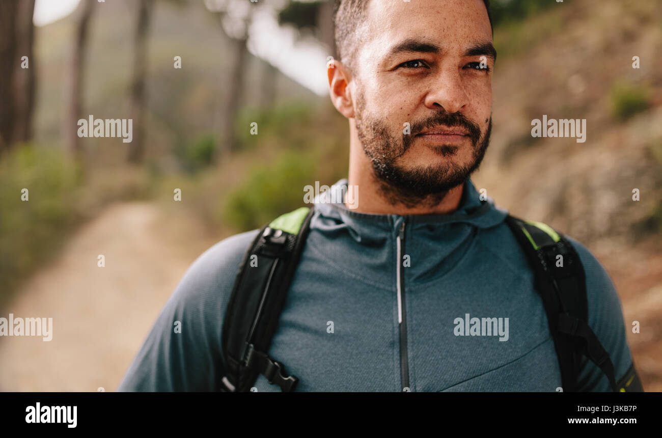 Porträt von Fit junge Mann im Freien auf Bergweg. Gesunde junge männliche Läufer auf Wald Trail wegsehen. Stockfoto