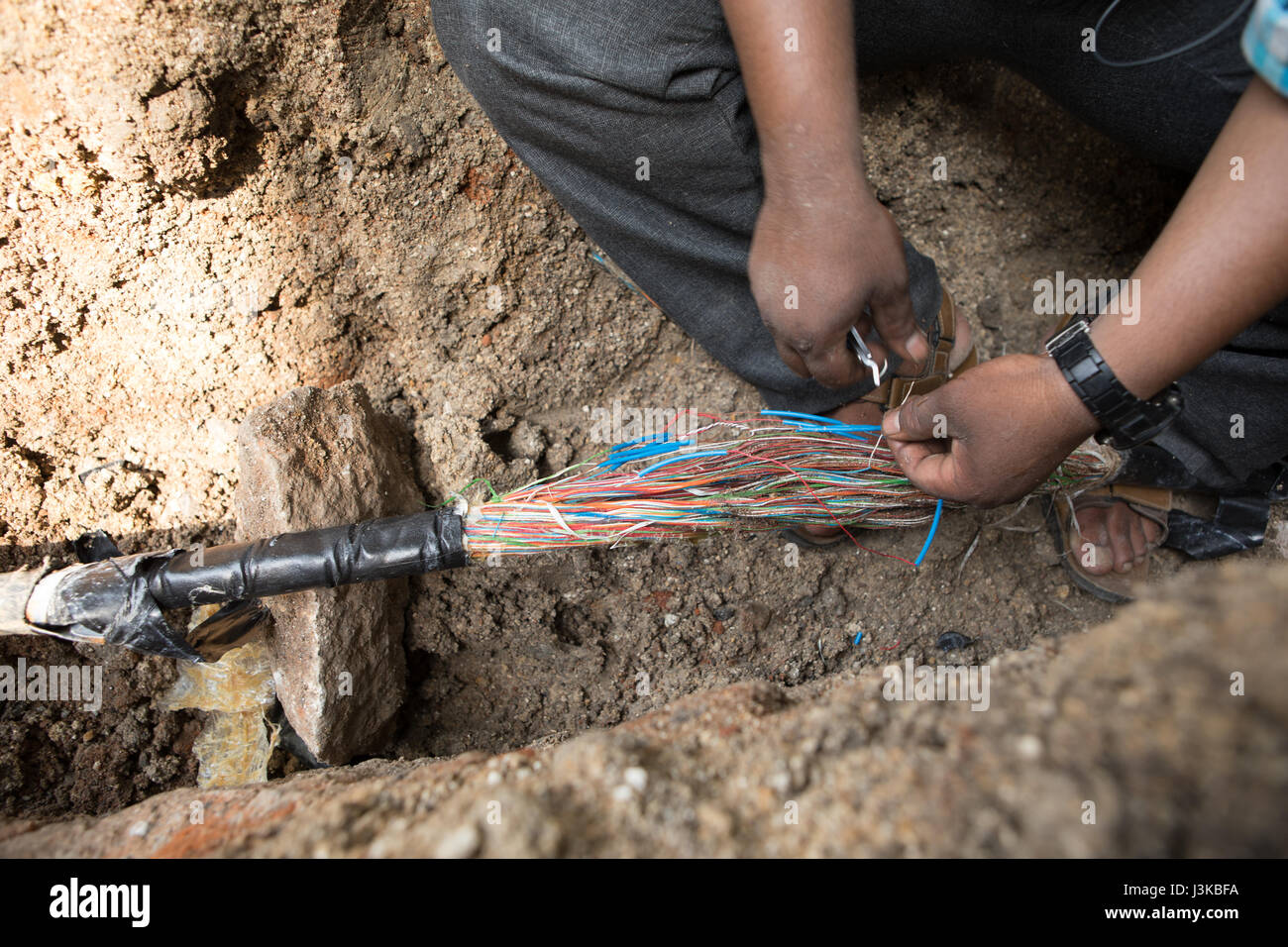 Indische Telefon Kabel-techniker Reparaturen ein beschädigtes Kabel in Hyderabad, Indien. Stockfoto