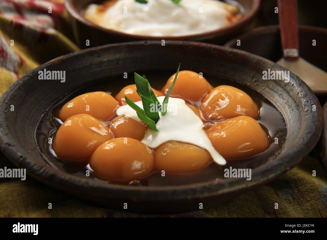 Traditionelle javanische Dessert Brei aus Klebreis und Süßkartoffel-Kugeln auf Steingut Geschirr Stockfoto