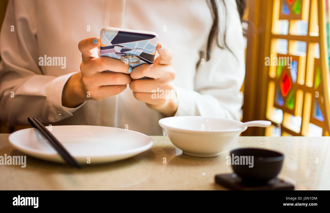 Mädchen mit Smartphone in einem restaurant Stockfoto