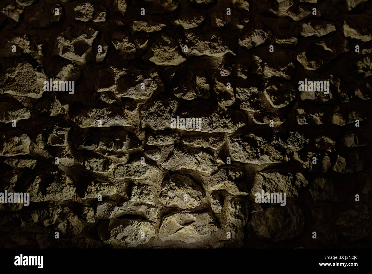 Dunkle Vintage Steinmauer Textur mit Spotlight im unteren Bereich. Stockfoto