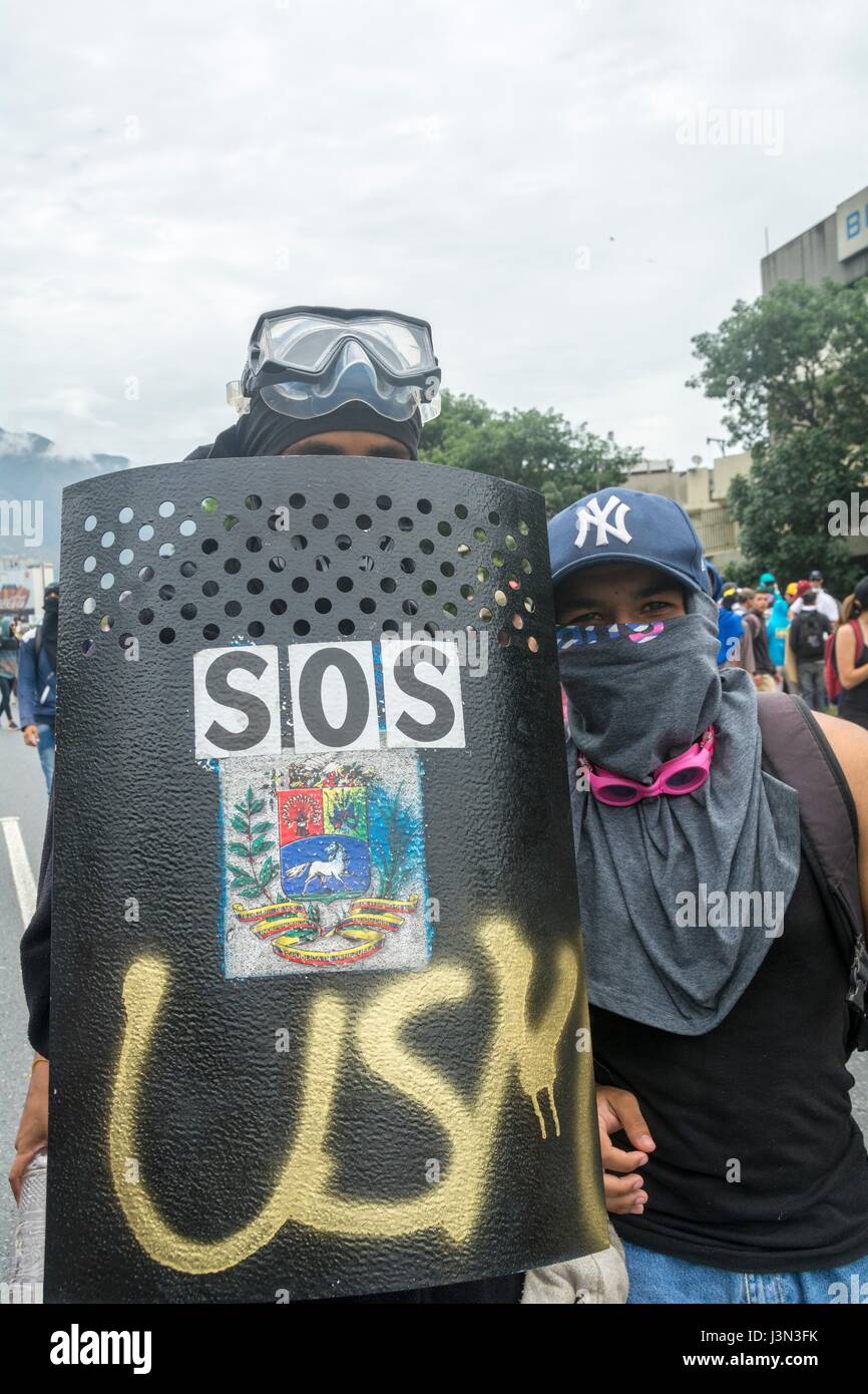 Anhänger der Opposition mit Metall Schilde und Steinen in ihren Händen während einer Demonstration gegen den venezolanischen Präsidenten Nicolás Maduro in Caracas, Vene Stockfoto