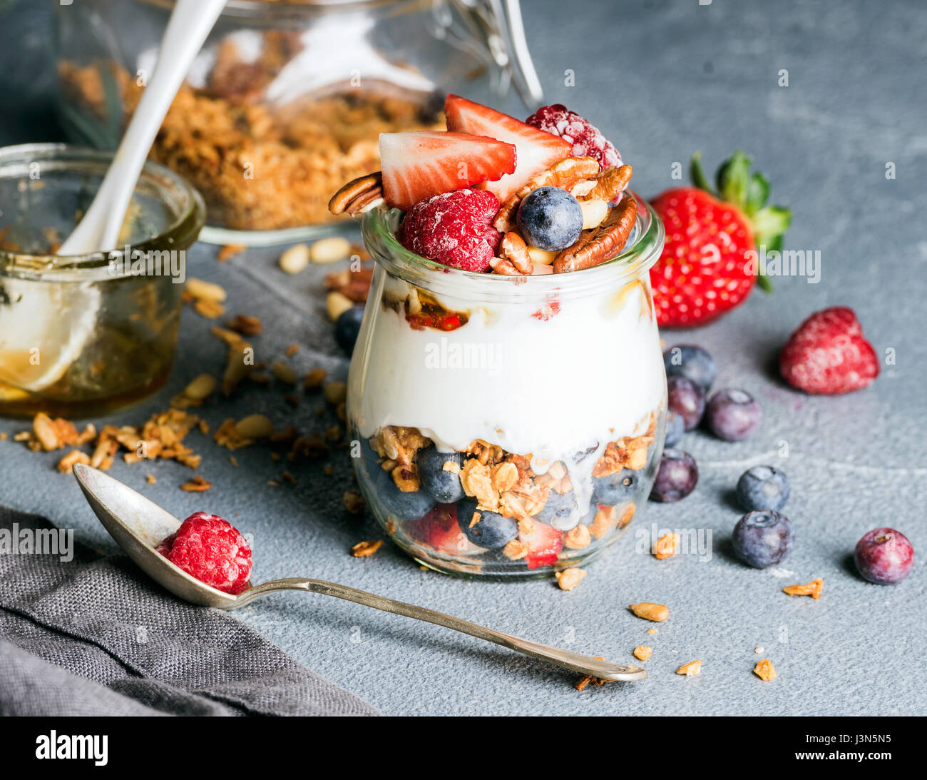 Joghurt-Hafer-Müsli mit frischen Beeren, Nüssen, Honig und Minze im ...