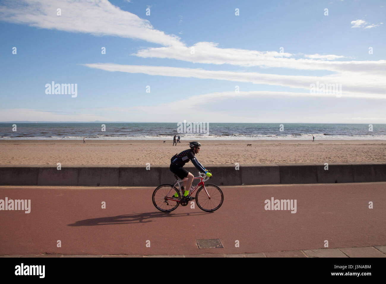 Edinburgh, Schottland. 6. Mai 2017. Mann, Radfahren an der Strandpromenade von Portobello Beach in Edinburgh, Schottland, Großbritannien. Wetter: 6. 2017 Temperaturen oberhalb Saisondurchschnitte abseits der Küsten, vor allem in West Lothian Höchststand kann. Aber es wird trüber als Freitag, besonders über den Süden durch und später über die Ostküste, wo einige niedrige Wolkendecke entwickelt. Bildnachweis: Gabriela Antosova/Alamy Live-Nachrichten Stockfoto